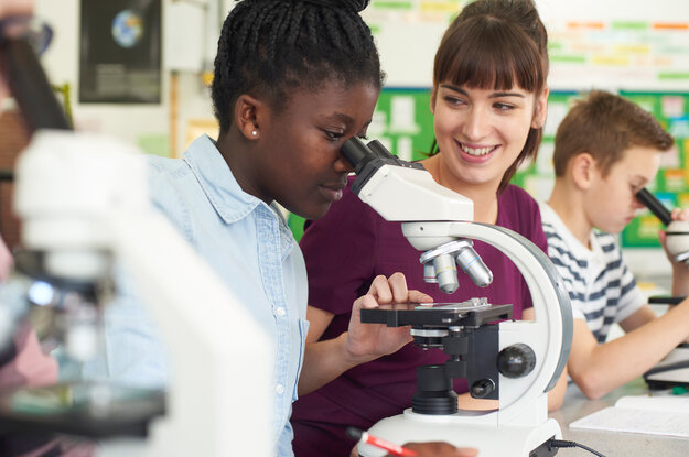 Zwei junge Frauen arbeiten mit einem Mikroskop.