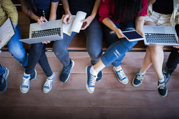 Füße von Jugendlichen mit Laptops und Tablet sind zu sehen.