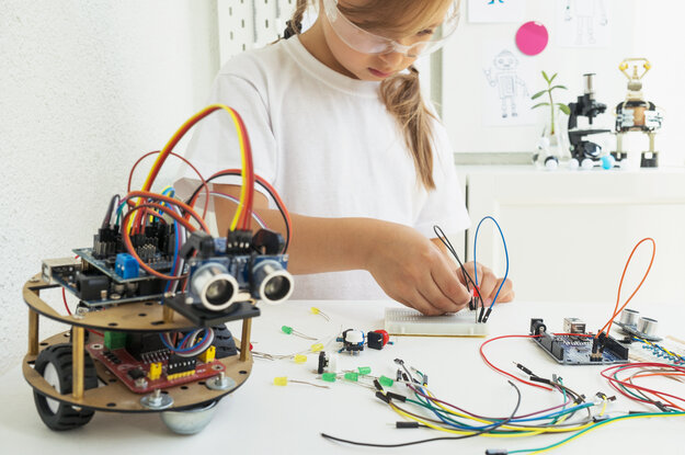 Ein Mädchen programmiert einen Roboter.